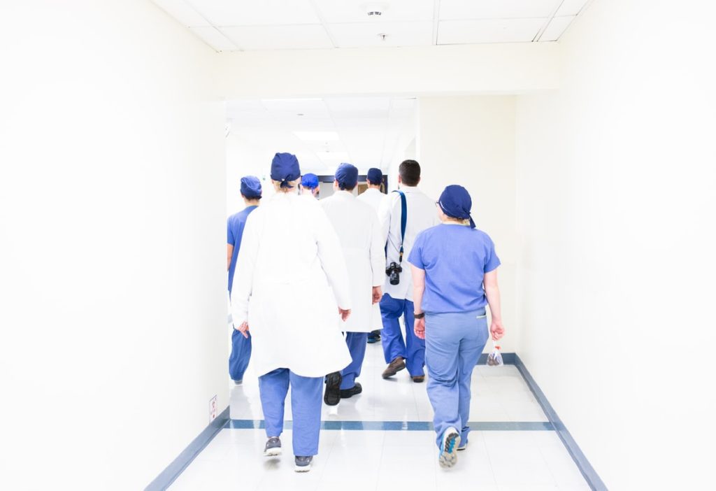 group of doctors and medical students walking down a corridor