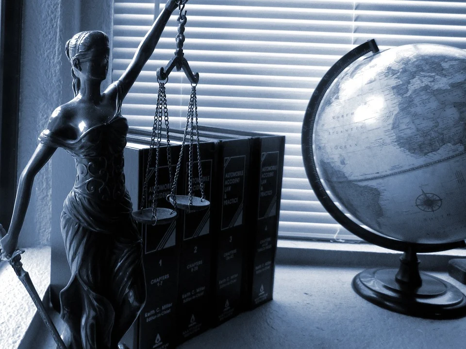 legal books statue and globe on a desk