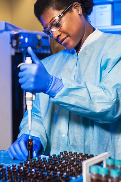 medical scientist using a pipette to measure fluid samples