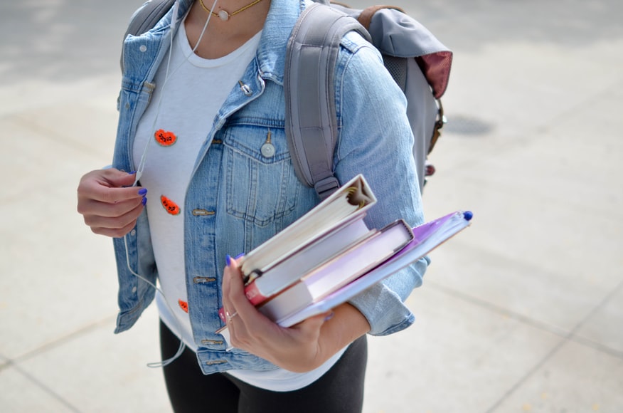 medical student with an arm full of books