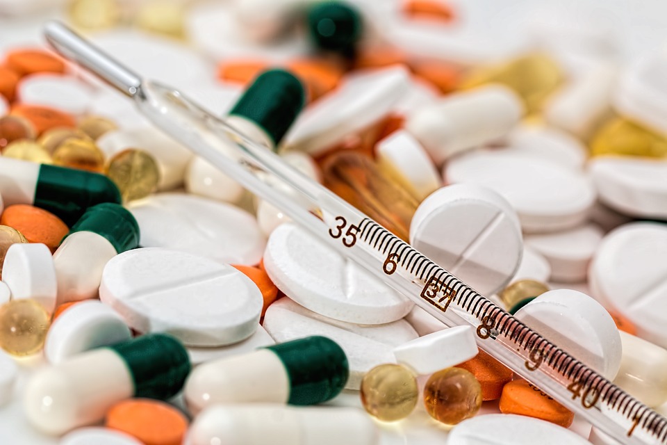 mix of various medical pills and a thermometer