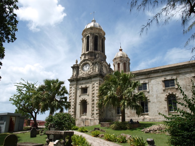 clocktower near green trees under blue sky in Antigua