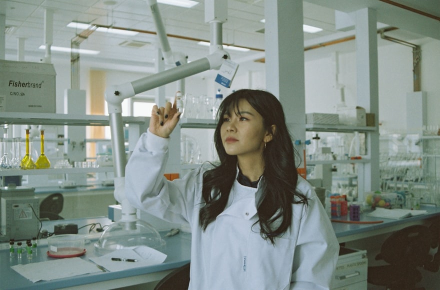 young woman looking at specimen in lab
